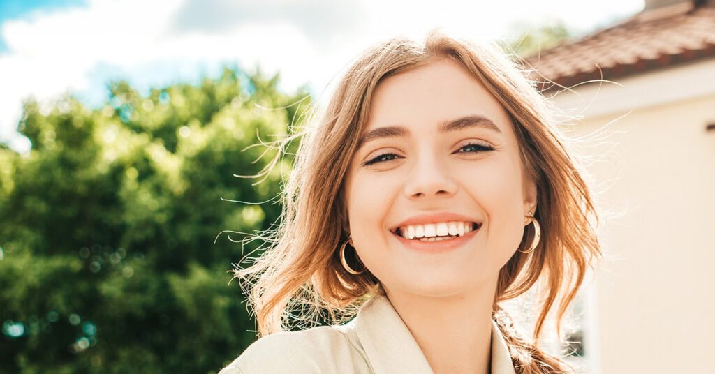 Portrait of young beautiful woman posing in the street