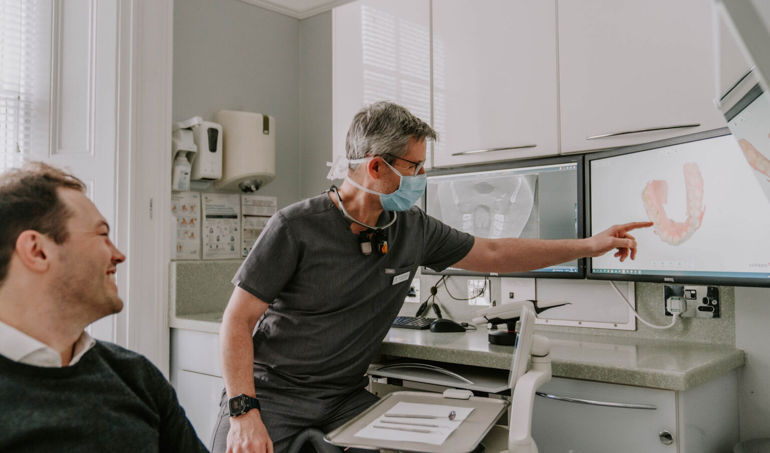 dentist with patient looking at dental scan